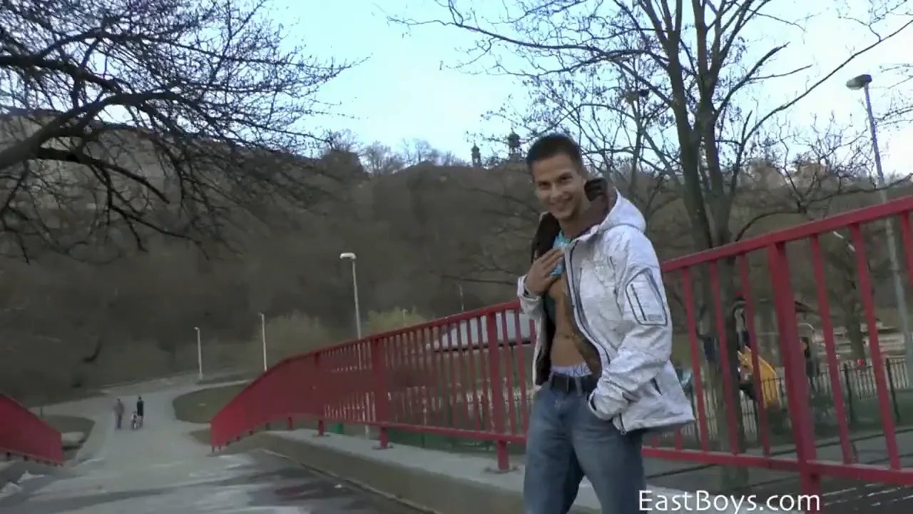 Young muscular gay hunk gives a massage in public on the street